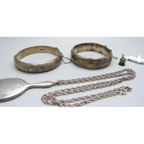 1002 - Two silver bangles (one a/f), a silver chain, a small silver hand mirror pendant, a silver thimble c... 