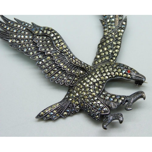 1004 - A large silver eagle brooch set with marcasite and a red stone eye, 6cm x 7.5cm