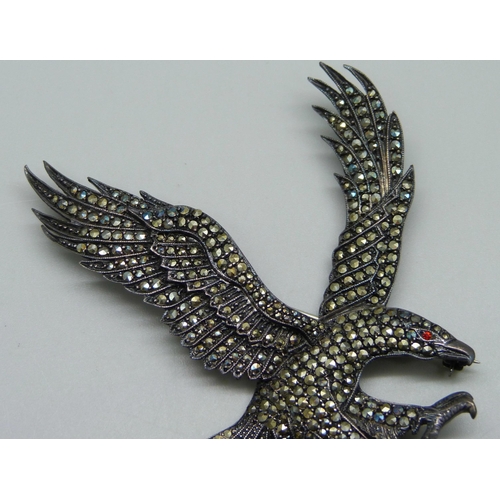 1004 - A large silver eagle brooch set with marcasite and a red stone eye, 6cm x 7.5cm