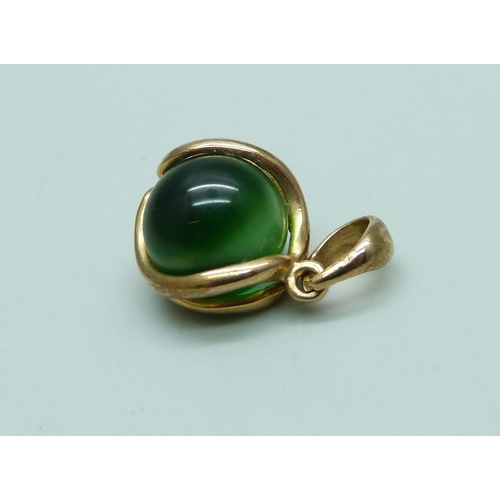 1056 - A yellow metal and green stone pendant or charm, total weight 2.8g