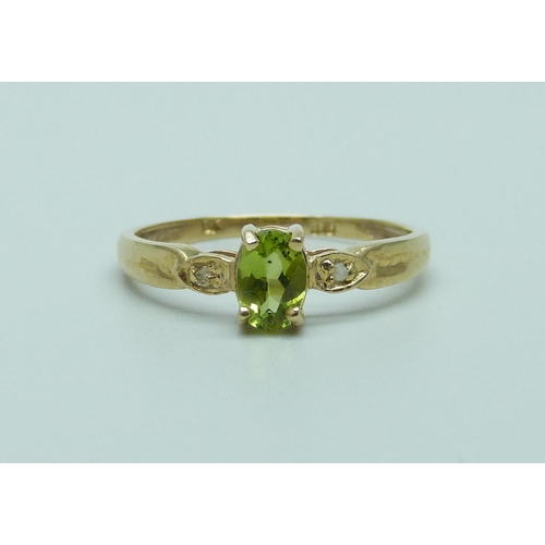 1075 - A 9ct gold ring set with an oval peridot and diamond accents, 1.1g, O