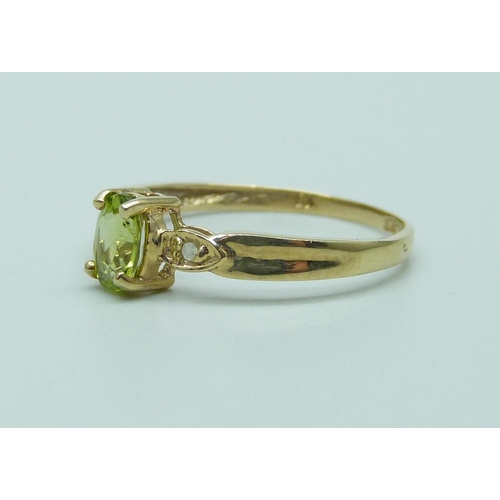 1075 - A 9ct gold ring set with an oval peridot and diamond accents, 1.1g, O