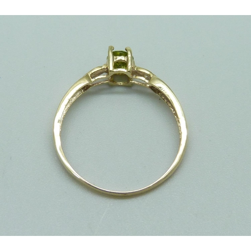 1075 - A 9ct gold ring set with an oval peridot and diamond accents, 1.1g, O