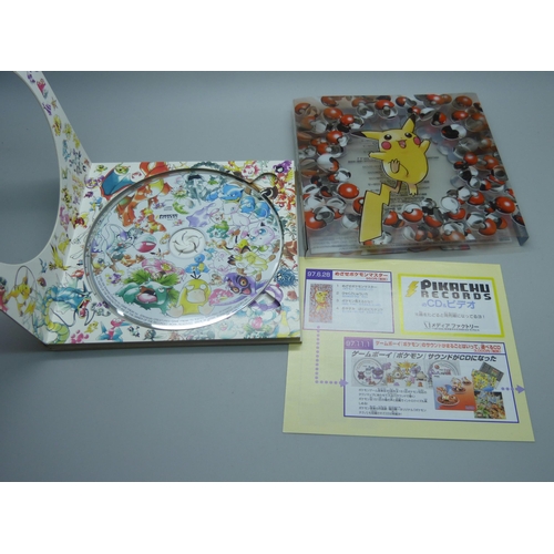 823 - A 1998 Pokemon Japanese Pikachu promo CD set, lacking cards, together with a 2000 Topps Pokemon TV o... 