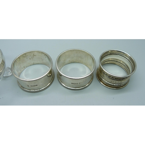 849 - Three silver napkin rings, 56g, and a silver topped salt