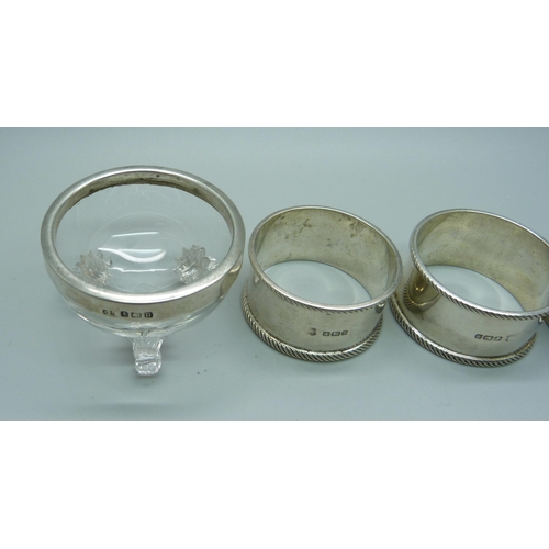 849 - Three silver napkin rings, 56g, and a silver topped salt