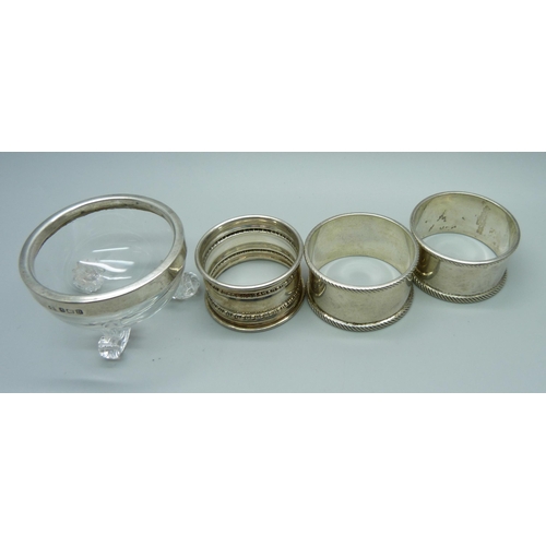 849 - Three silver napkin rings, 56g, and a silver topped salt