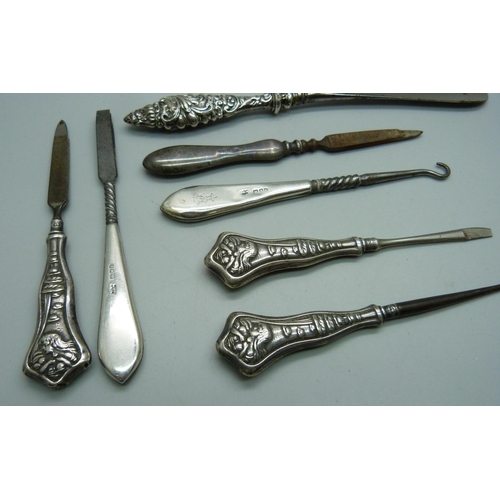 895 - A collection of silver handled button hooks and shoe horns