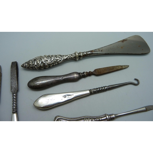 895 - A collection of silver handled button hooks and shoe horns