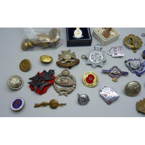 900 - A collection of military cap badges, buttons, other badges, etc.