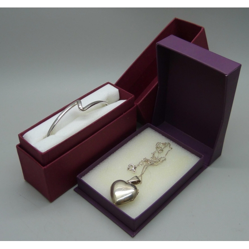 910 - A silver bangle set with a diamond and a silver heart shaped pendant and chain