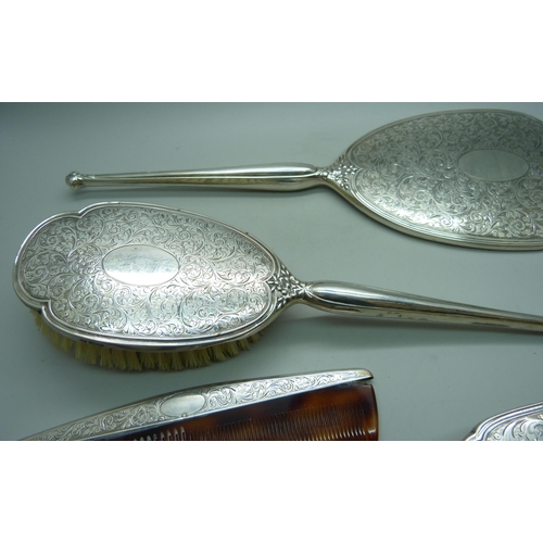 913 - A four piece silver hand mirror set and one other silver comb