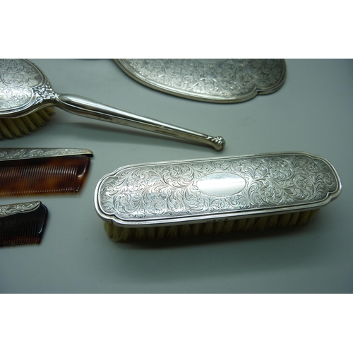 913 - A four piece silver hand mirror set and one other silver comb