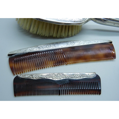 913 - A four piece silver hand mirror set and one other silver comb