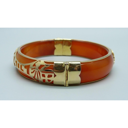 964 - A yellow metal mounted jade bangle with oriental fretwork detail, stamped 14k