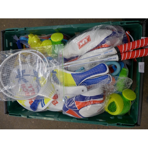 2342 - A crate of beach/outdoor play toys including a badminton set, rugby balls, buckets and spades, water... 