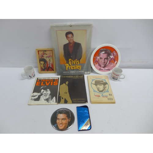 2355 - A crate of Elvis items including calendars, magazines, posters, mugs, pictures, first day covers, bo... 