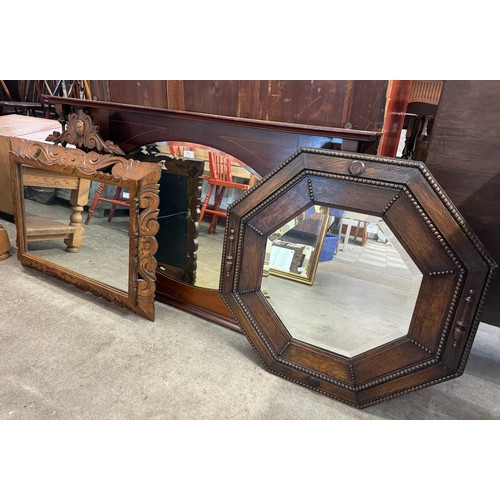 392 - An early 20th century carved oak octagonal mirror and two others