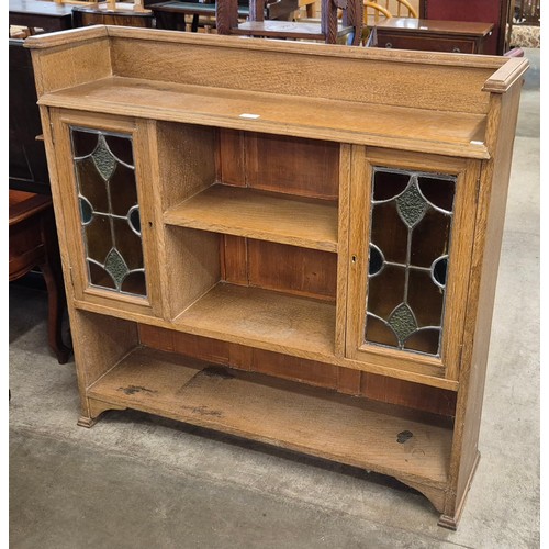 111R - An Arts and Crafts oak and stained glass two door bookcase