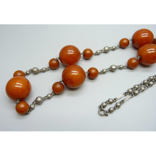 1003 - A large amber coloured bead necklace mounted on a white metal chain