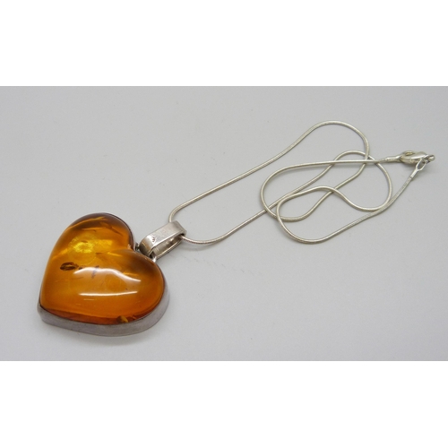 1005 - A silver mounted amber pendant on chain, 40mm wide