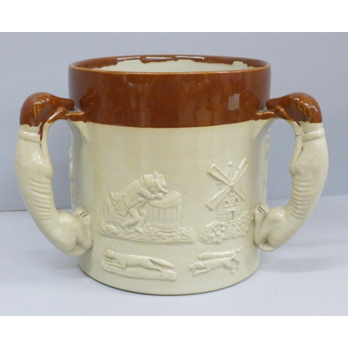 607 - A salt glazed stoneware ale tyg, in relief, with three greyhound handles, 16cm