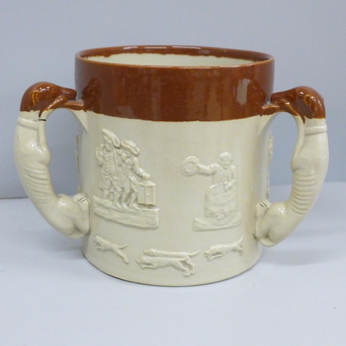 607 - A salt glazed stoneware ale tyg, in relief, with three greyhound handles, 16cm