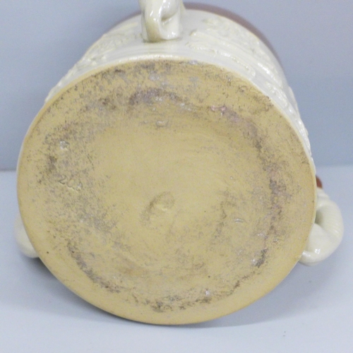 607 - A salt glazed stoneware ale tyg, in relief, with three greyhound handles, 16cm