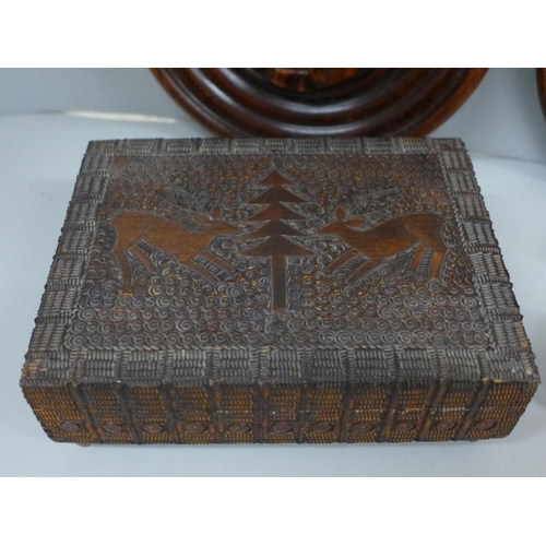 698 - A carved wooden musical box, two other carved wooden boxes and two circular wooden plaques