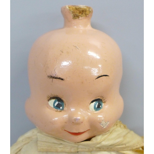 740 - A doll with wooden head and limbs with three faced head and stuffed body