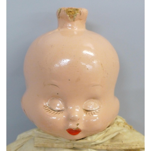 740 - A doll with wooden head and limbs with three faced head and stuffed body