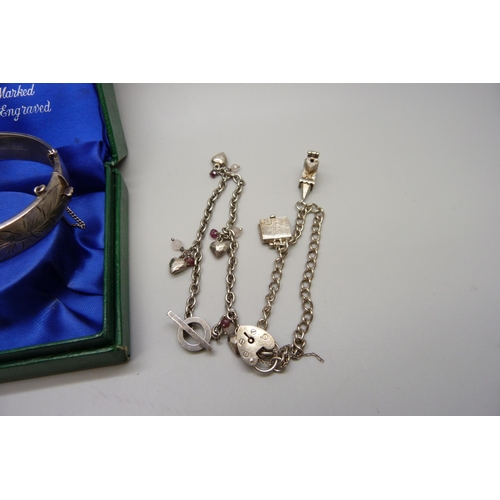 879 - A vintage silver bangle in original box and two silver charm bracelets, 51g