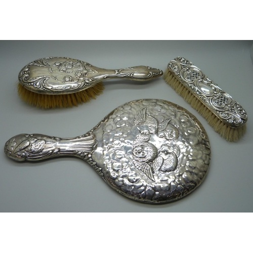 881 - A Reynolds Angels silver mirror, Chester 1981, and two silver backed brushes