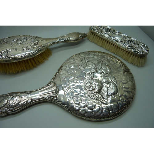 881 - A Reynolds Angels silver mirror, Chester 1981, and two silver backed brushes