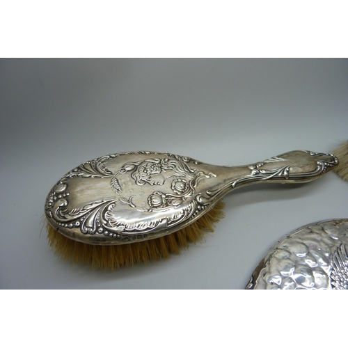 881 - A Reynolds Angels silver mirror, Chester 1981, and two silver backed brushes