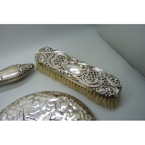 881 - A Reynolds Angels silver mirror, Chester 1981, and two silver backed brushes