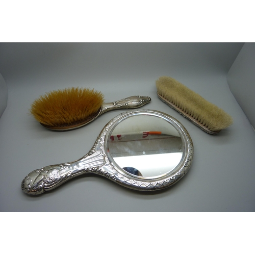 881 - A Reynolds Angels silver mirror, Chester 1981, and two silver backed brushes