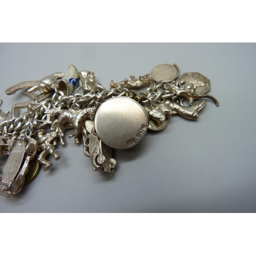 922 - A heavy charm bracelet with silver and white metal charms and coins, total weight 164g