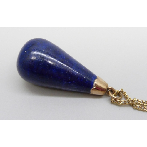 924 - A large yellow metal mounted lapis lazuli pendant on a 9ct gold chain, chain 2g and 40cm