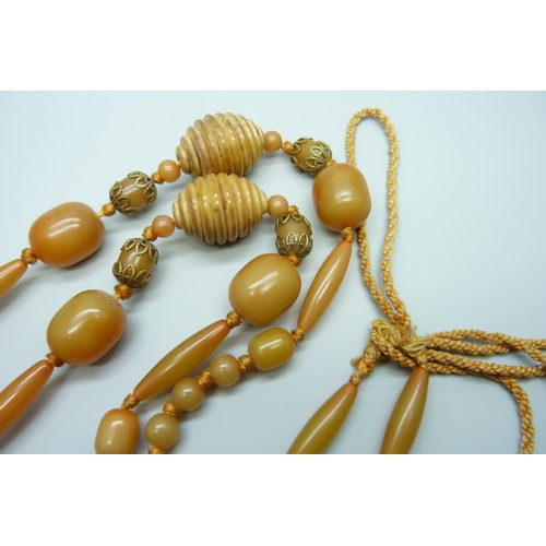 932 - An amber coloured and carved bead necklace