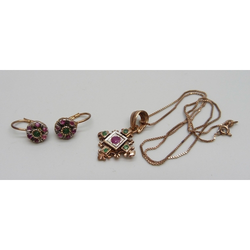 945 - A silver gilt ruby and emerald set pendant on a chain and a pair of matching earrings