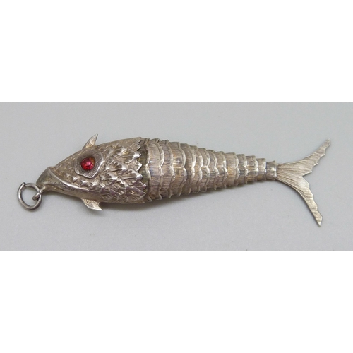 953 - A white metal articulated fish pendant with red paste set eyes, continental control marks, 75mm