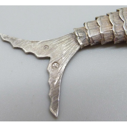 953 - A white metal articulated fish pendant with red paste set eyes, continental control marks, 75mm