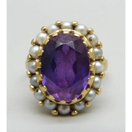 955 - An 18ct gold ring set with an amethyst and seed pearls, stamped 750, 7.7g, N