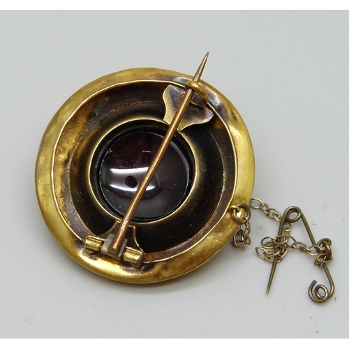 976 - A Victorian yellow metal brooch set with a cabochon garnet, 8g, 30mm