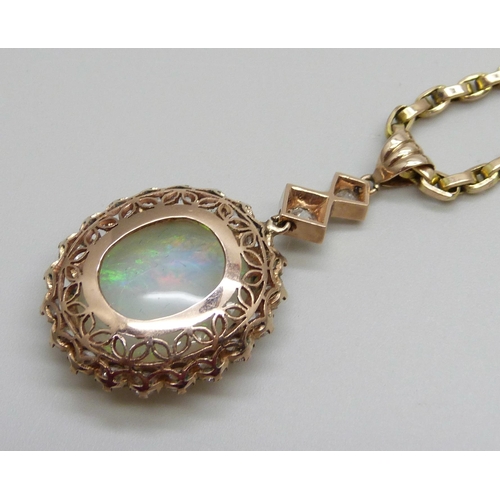 980 - A yellow metal cluster drop pendant set with a central opal and white stone border, on a 9ct gold ch... 