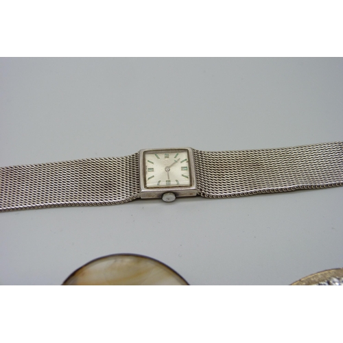 981 - A silver wristwatch with mesh style strap, a silver St Christopher pendant, a silver stone set brooc... 