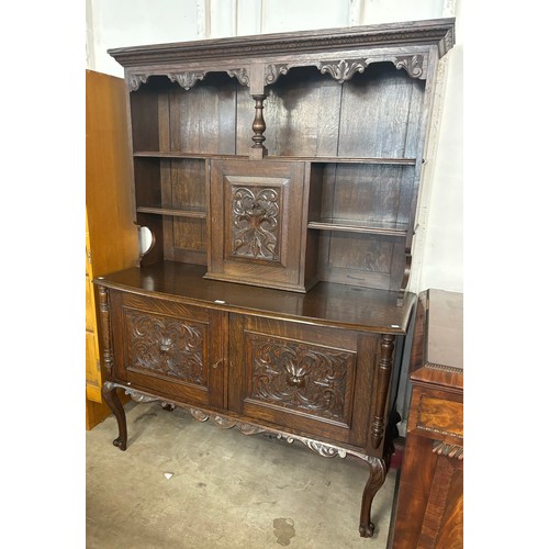 125 - An early 20th Century Jacobean Revival Green Man carved oak dresser