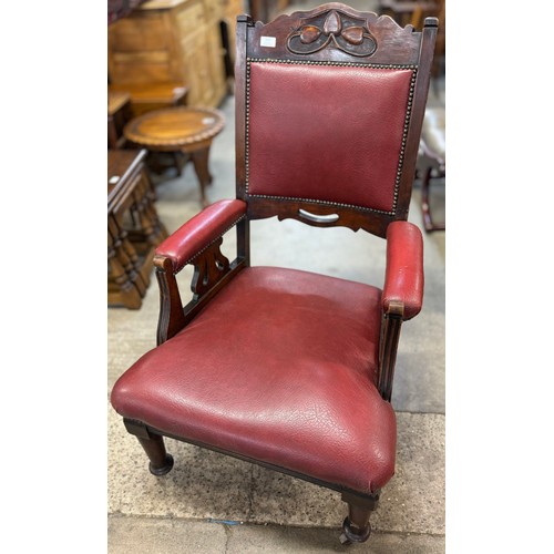 203 - An Arts and Crafts carved beech and red faux leather armchair