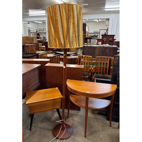 87 - A teak sewing box, demi lune hall table and a teak standard lamp